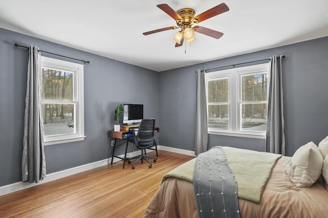 bedroom with a ceiling fan, baseboards, and wood finished floors