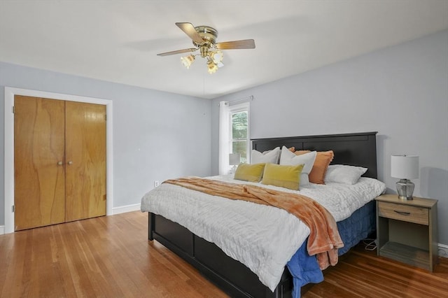 bedroom featuring wood finished floors, a ceiling fan, and baseboards