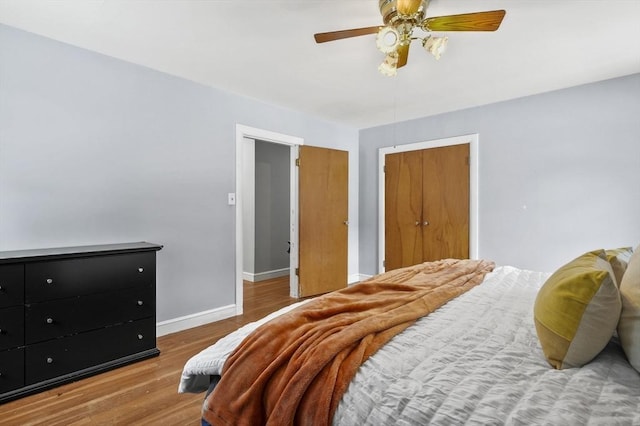 bedroom featuring a ceiling fan, baseboards, and wood finished floors