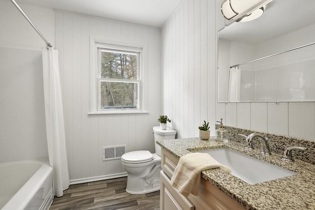 bathroom with toilet, shower / tub combo, wood finished floors, vanity, and visible vents