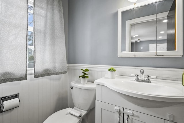 bathroom featuring wainscoting, vanity, and toilet