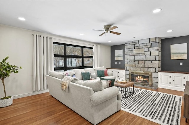 living room with ceiling fan, a fireplace, wood finished floors, and recessed lighting