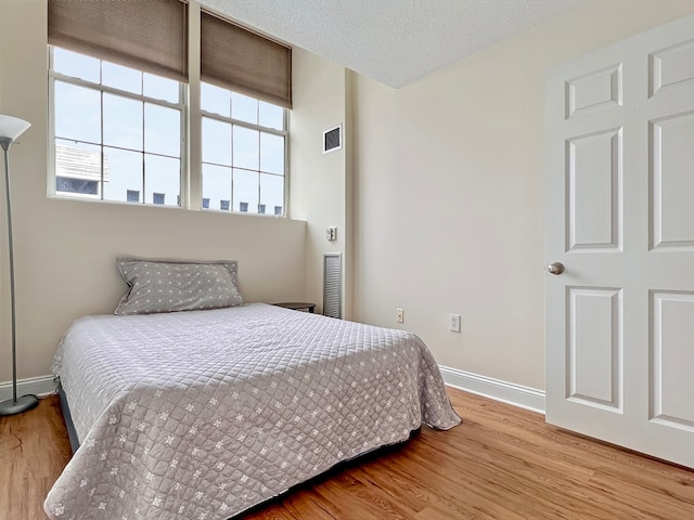 bedroom featuring wood-type flooring and a textured ceiling