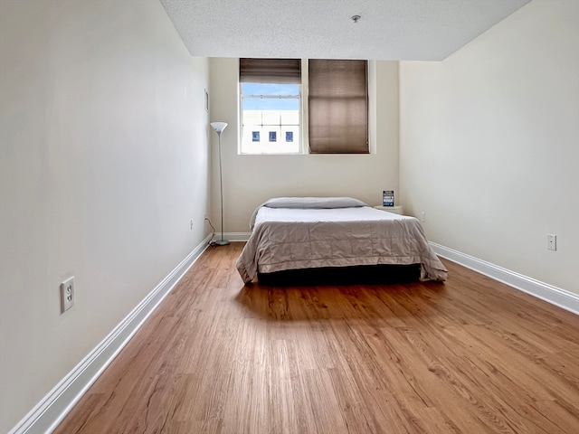 bedroom with wood-type flooring and a textured ceiling