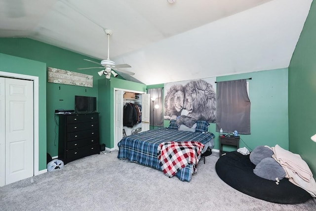 carpeted bedroom with two closets, vaulted ceiling, and ceiling fan