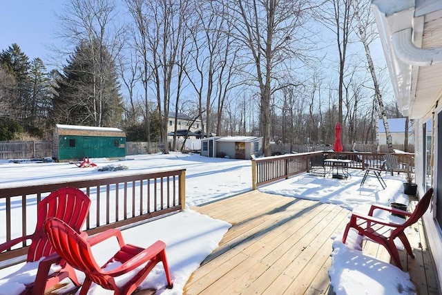 snow covered deck with a storage shed