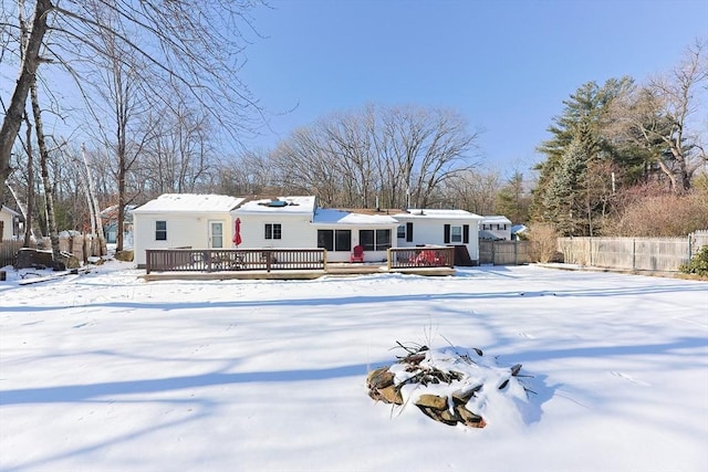 snow covered house featuring a wooden deck