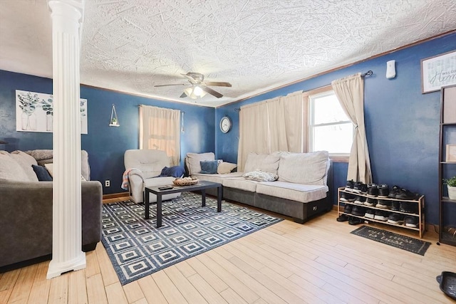 living room featuring ornate columns, hardwood / wood-style flooring, a textured ceiling, and ceiling fan