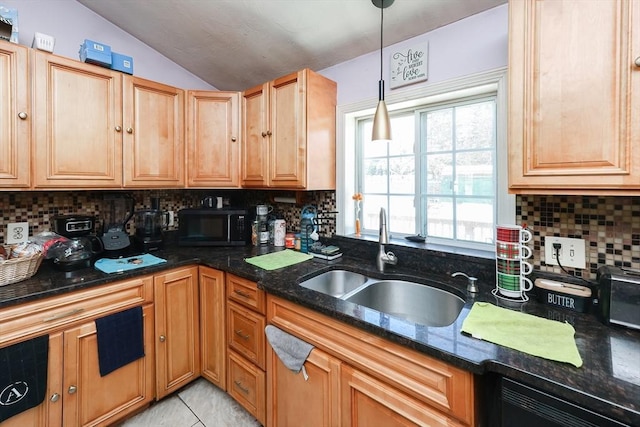 kitchen with vaulted ceiling, decorative light fixtures, tasteful backsplash, sink, and dark stone countertops