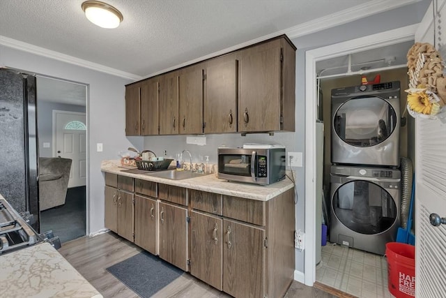 42 Charlotte Furnace Rd, Wareham, MA 02576 - kitchen with stainless steel microwave, estacked washer and dryer, light countertops, freestanding refrigerator, and crown molding