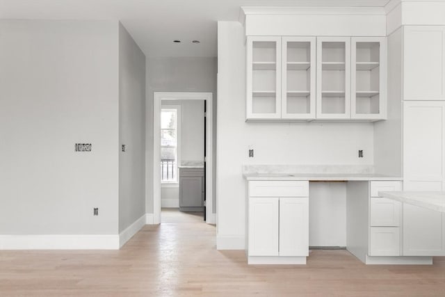 kitchen with light wood-style floors, white cabinets, and glass insert cabinets