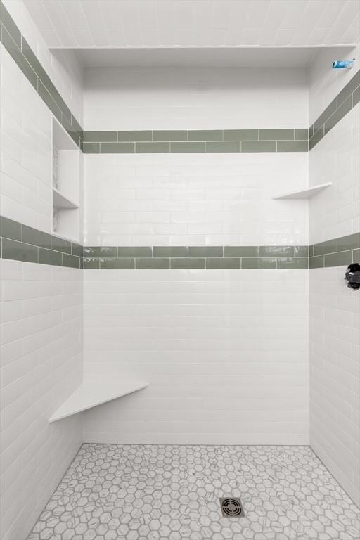 full bath with tile walls and a tile shower