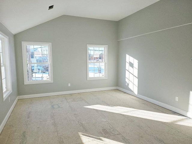 spare room featuring a healthy amount of sunlight and vaulted ceiling