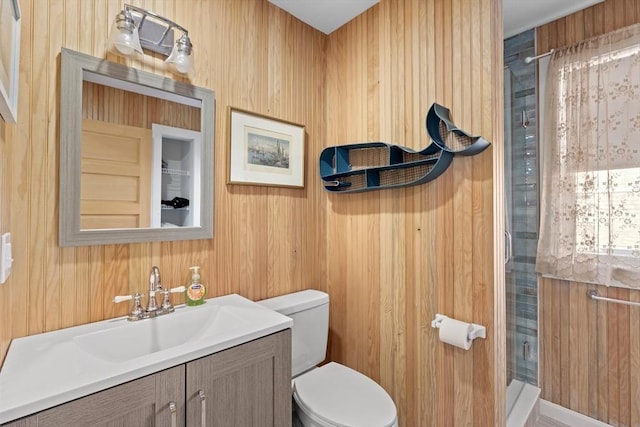 bathroom featuring toilet, a shower, wood walls, and vanity