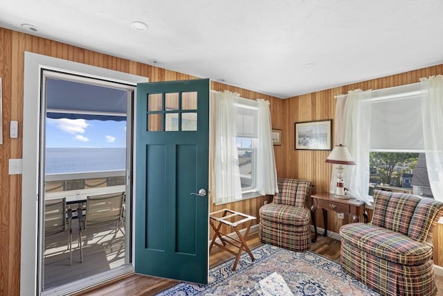 living area featuring plenty of natural light, hardwood / wood-style floors, and a water view