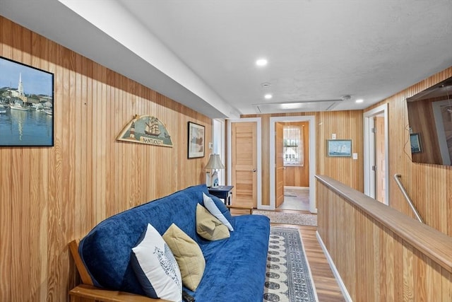 living area with hardwood / wood-style flooring and wood walls