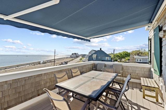 exterior space with a water view, a beach view, and a balcony