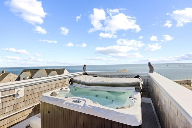 view of patio / terrace with a water view and a hot tub