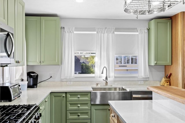 kitchen with sink, stainless steel appliances, and green cabinetry