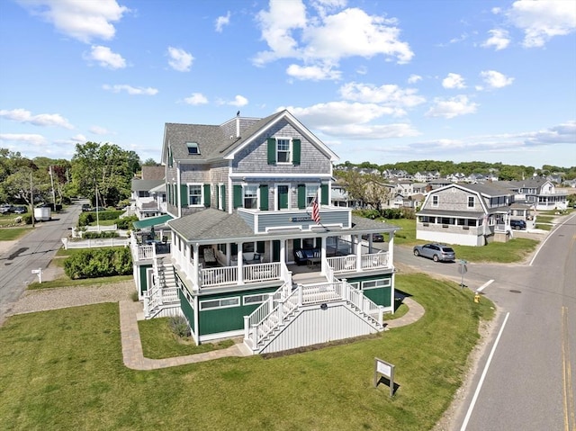 rear view of house with a lawn and a porch