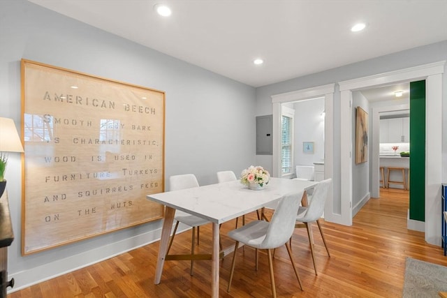 dining space featuring light wood-type flooring and electric panel