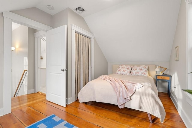 bedroom featuring hardwood / wood-style floors and vaulted ceiling