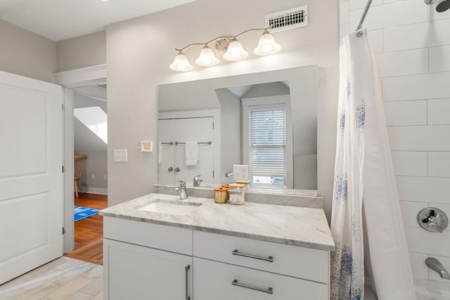 bathroom featuring hardwood / wood-style flooring, shower / tub combo, and vanity