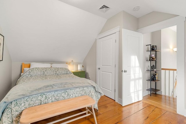 bedroom featuring hardwood / wood-style flooring and lofted ceiling