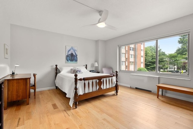 22 Chestnut Pl Unit 111, Brookline, MA 02445 - bedroom with light wood finished floors, ceiling fan, and radiator heating unit