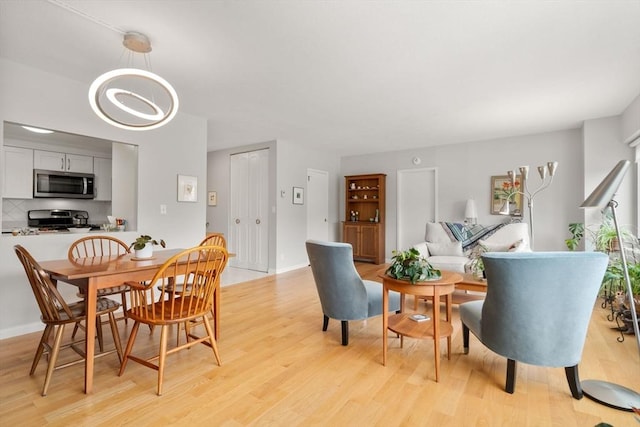 22 Chestnut Pl Unit 111, Brookline, MA 02445 - dining area featuring light wood-type flooring and a chandelier