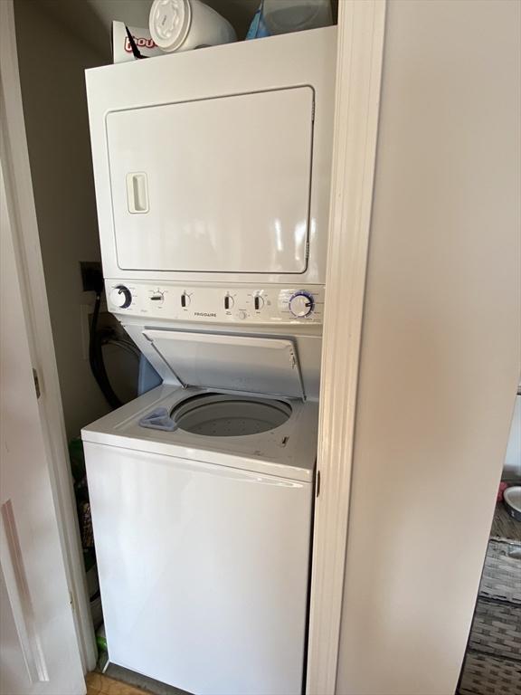 clothes washing area featuring laundry area and stacked washer / drying machine