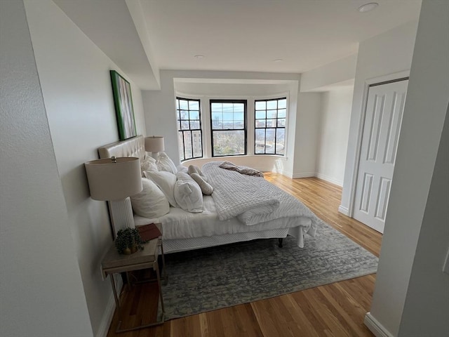 bedroom featuring wood finished floors and baseboards