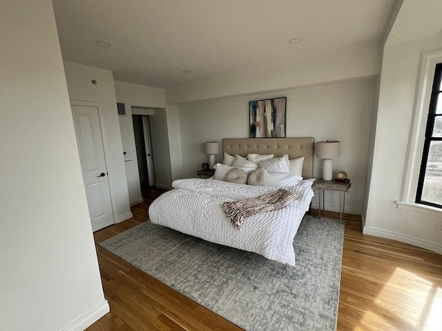 bedroom with baseboards and wood finished floors