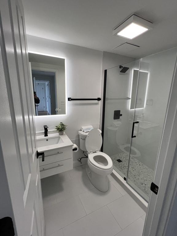 bathroom with tile patterned flooring, a shower stall, toilet, and vanity