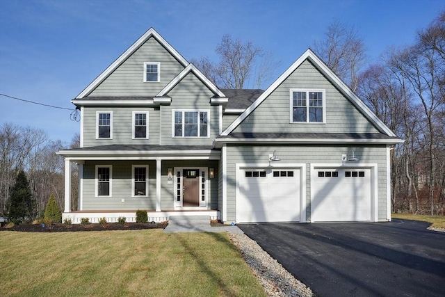 view of front of house with a porch, a garage, and a front yard