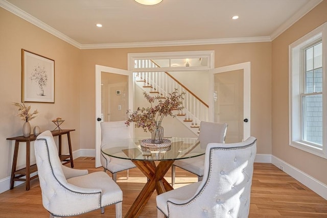 dining area with light hardwood / wood-style flooring and crown molding