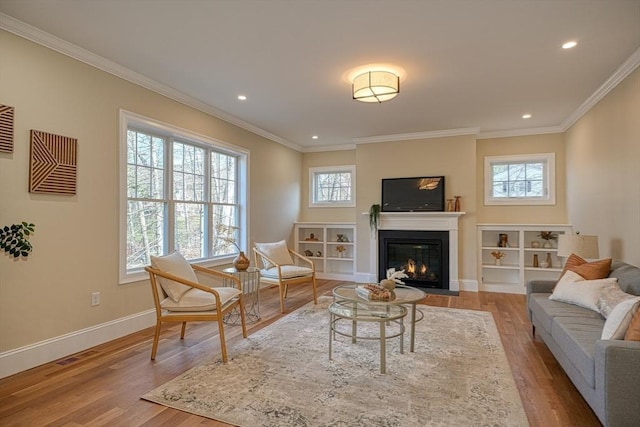 living area featuring ornamental molding and light wood-type flooring