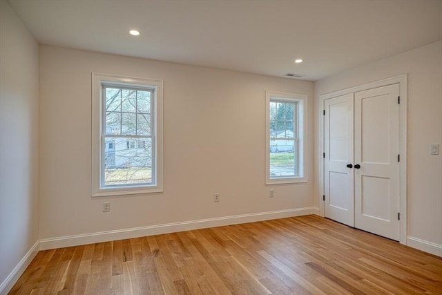 empty room with light wood-type flooring and a wealth of natural light