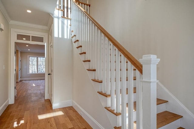 stairway featuring hardwood / wood-style floors and ornamental molding