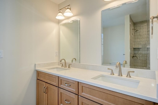 bathroom with tiled shower and vanity