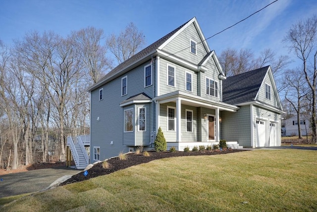 view of property with a porch, a garage, and a front lawn