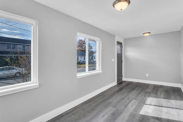 unfurnished room with dark wood-type flooring