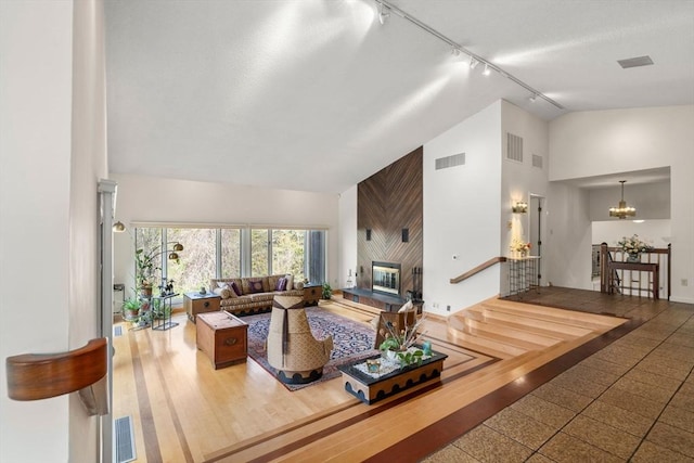 16 Wadsworth Ln, Dartmouth, MA 02748 - living room with rail lighting, high vaulted ceiling, a chandelier, and wood walls