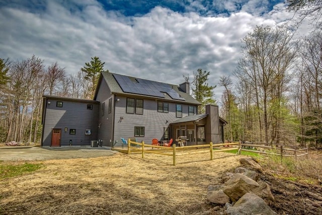 56 Otis-Tolland Rd, Blandford, MA 01008 - rear view of house featuring solar panels, a chimney, and a patio area