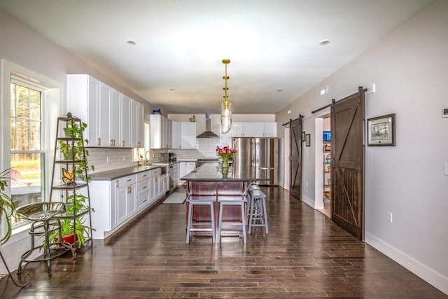 56 Otis-Tolland Rd, Blandford, MA 01008 - kitchen with freestanding refrigerator, a barn door, tasteful backsplash, white cabinets, and dark wood-style flooring
