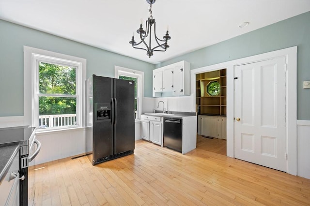 661 Main St, Hanson, MA 02341 - kitchen with black appliances, a chandelier, white cabinetry, and light wood-style flooring