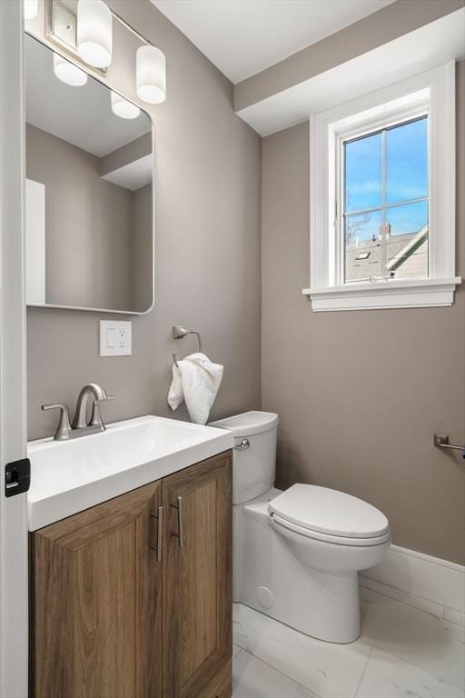 110 Fayette Unit 110, Watertown, MA 02472 - half bathroom featuring vanity, marble finish floor, baseboards, and toilet