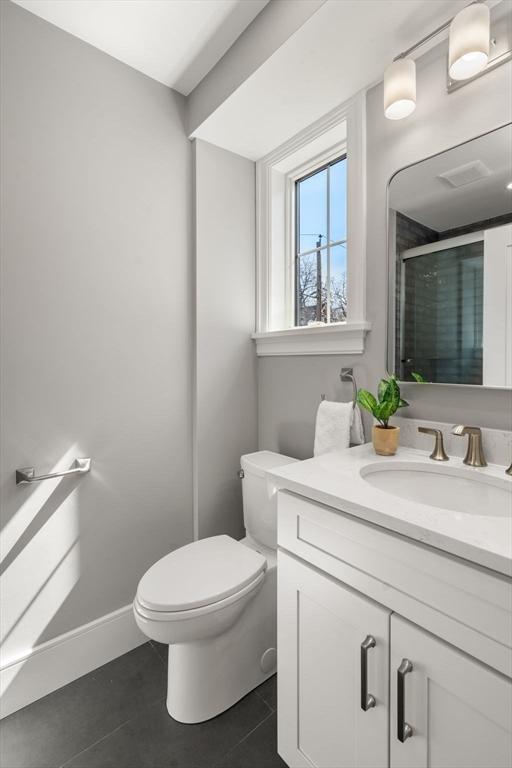 110 Fayette Unit 110, Watertown, MA 02472 - bathroom with baseboards, toilet, vanity, tile patterned floors, and a stall shower