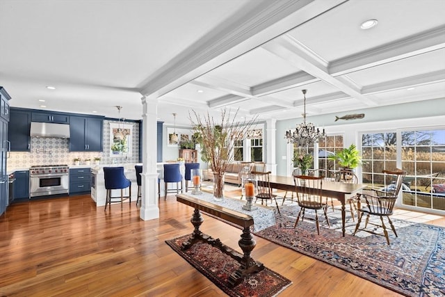 interior space with an inviting chandelier, beamed ceiling, decorative columns, and coffered ceiling