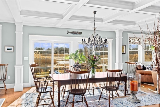 dining room featuring beamed ceiling, light wood finished floors, and ornate columns